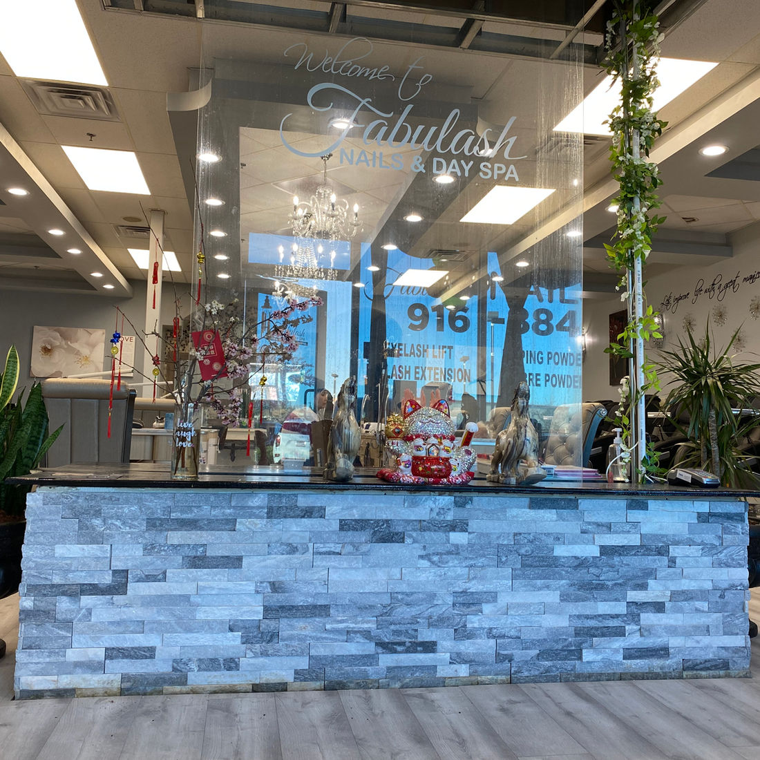 Fabulash reception desk with stone wall and greenery